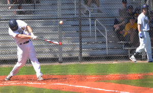 A college baseball player hits the ball during the RussMatt Tournament
